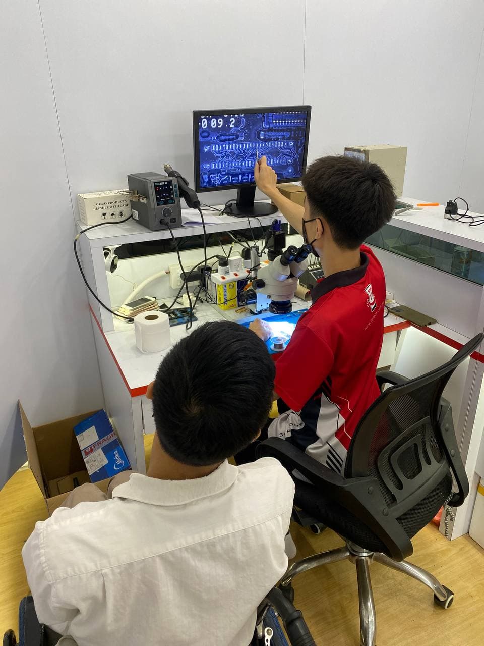Students analysing PCB layout on large monitor
