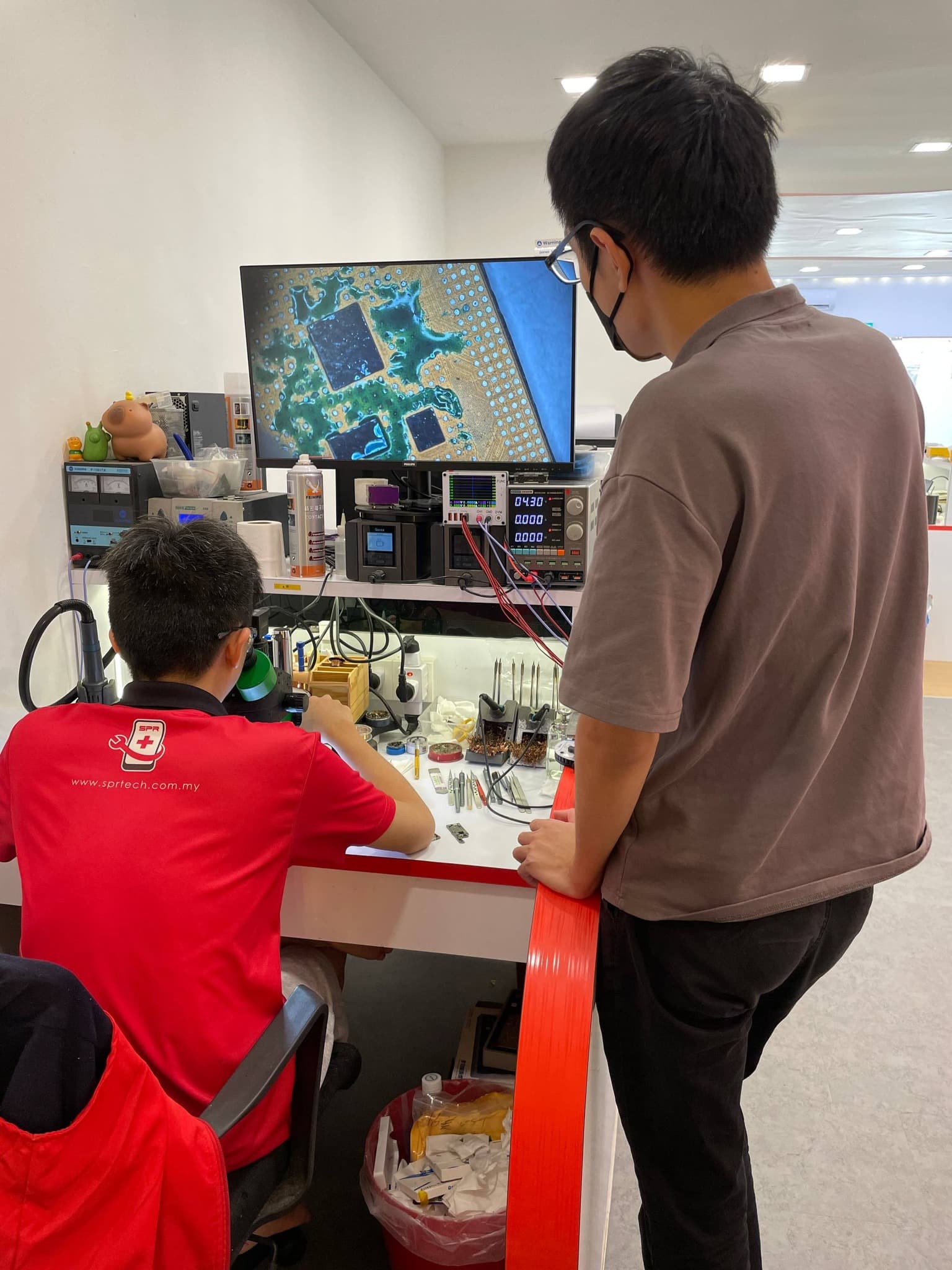 Students inspecting chips via microscope display
