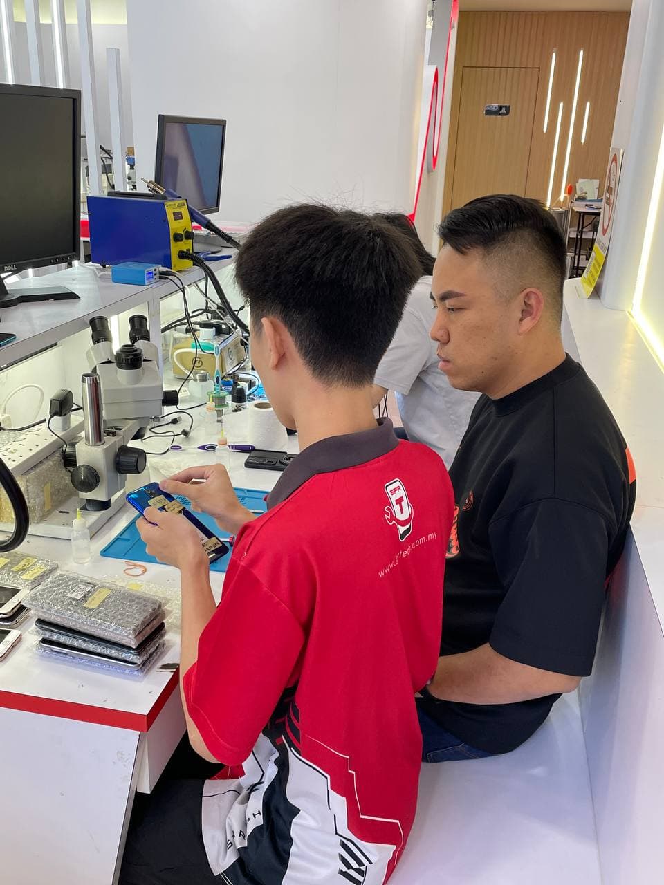 Two students learning phone repair together